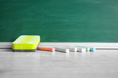 Photo of Chalk and duster on table in classroom