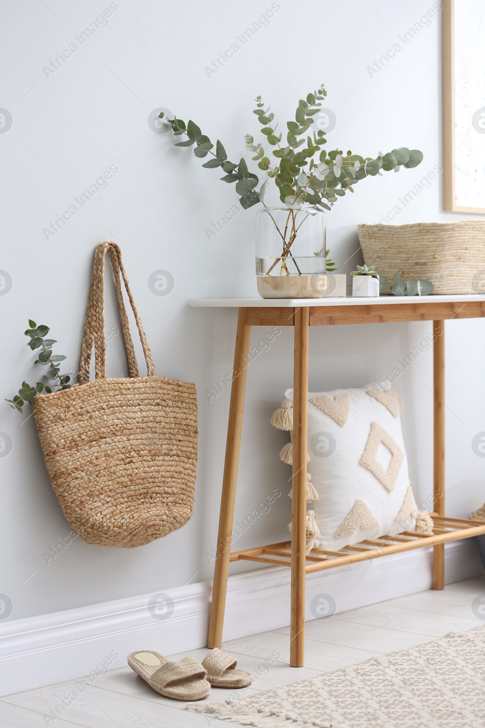 Photo of Vase with fresh eucalyptus branches on table in room. Interior design