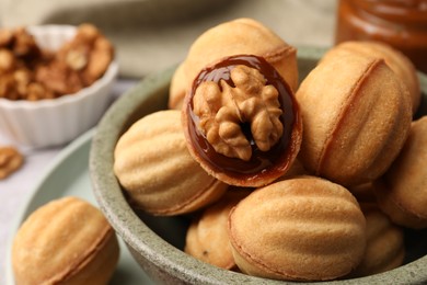 Delicious nut shaped cookies with boiled condensed milk in bowl, closeup