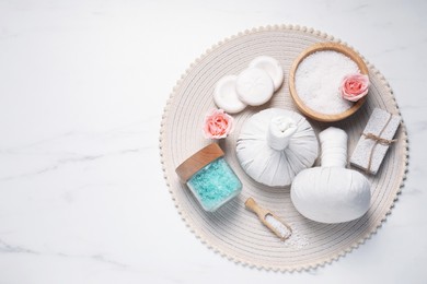 Photo of Composition of herbal bags and spa products on white marble table, top view. Space for text
