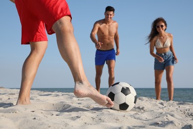 Photo of Group of friends playing football on beach