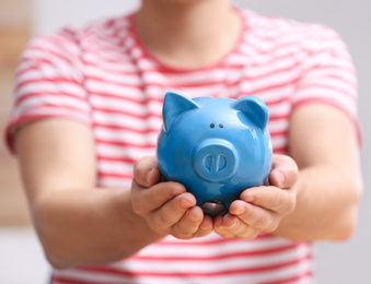 Man holding piggy bank on light background, closeup