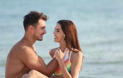 Happy young couple at beach on sunny day