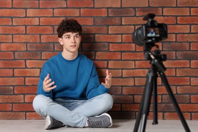 Photo of Teenage blogger explaining something while streaming indoors