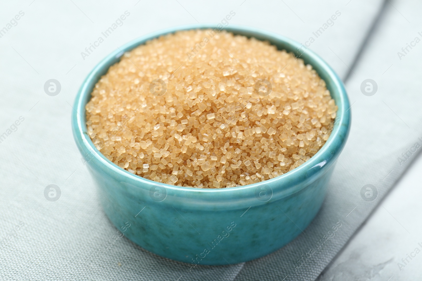 Photo of Brown sugar in bowl on table, closeup