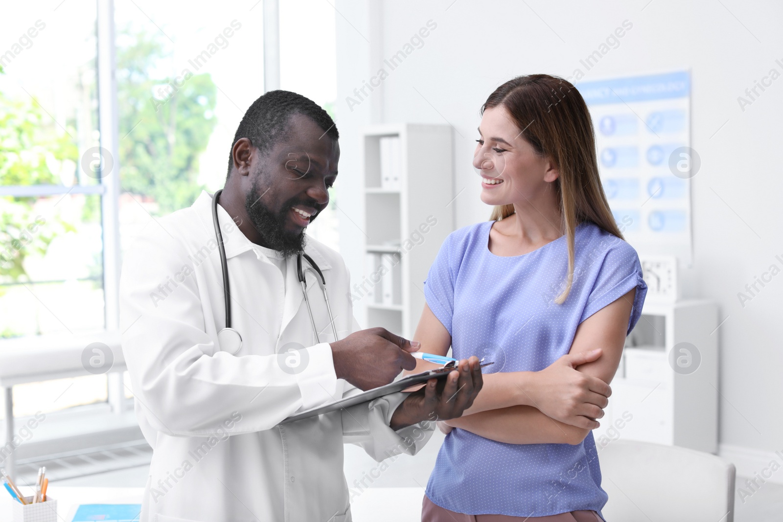 Photo of Young African-American doctor consulting patient in modern hospital