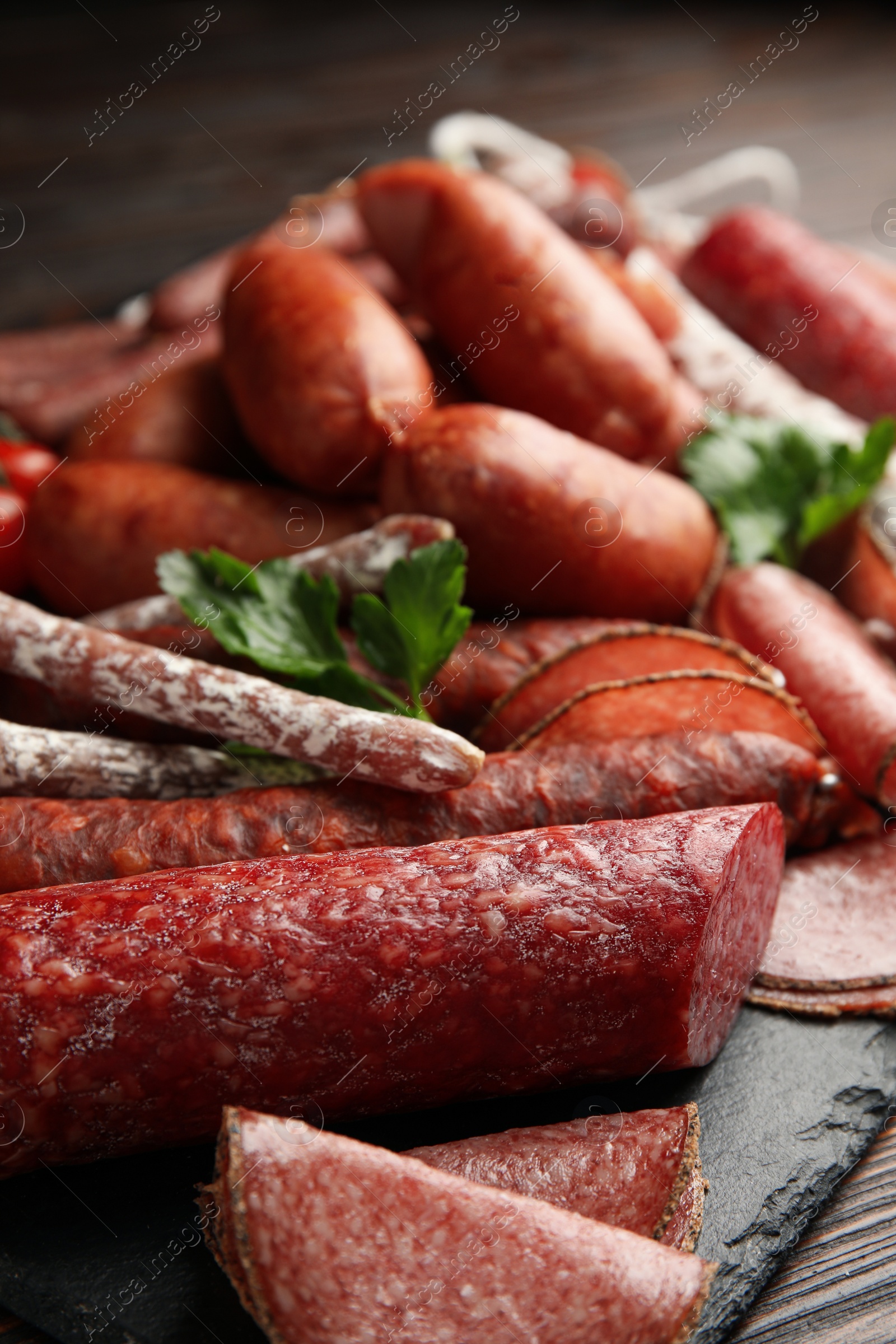 Photo of Different tasty sausages on wooden table, closeup