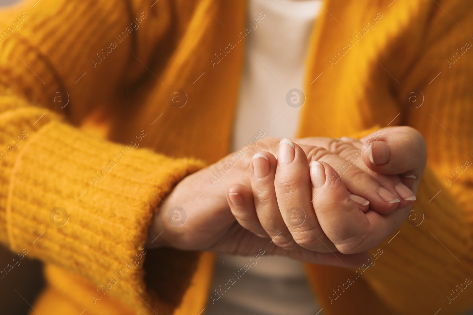 Photo of Elderly woman in orange cardigan, closeup view