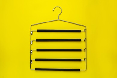 Empty hanger on yellow background, top view