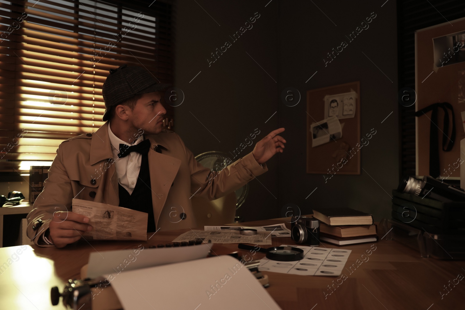 Photo of Old fashioned detective working at table in office