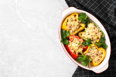 Photo of Tasty stuffed bell peppers in baking dish on light table, top view. Space for text