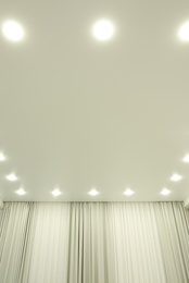 White stretch ceiling with spot lights in room