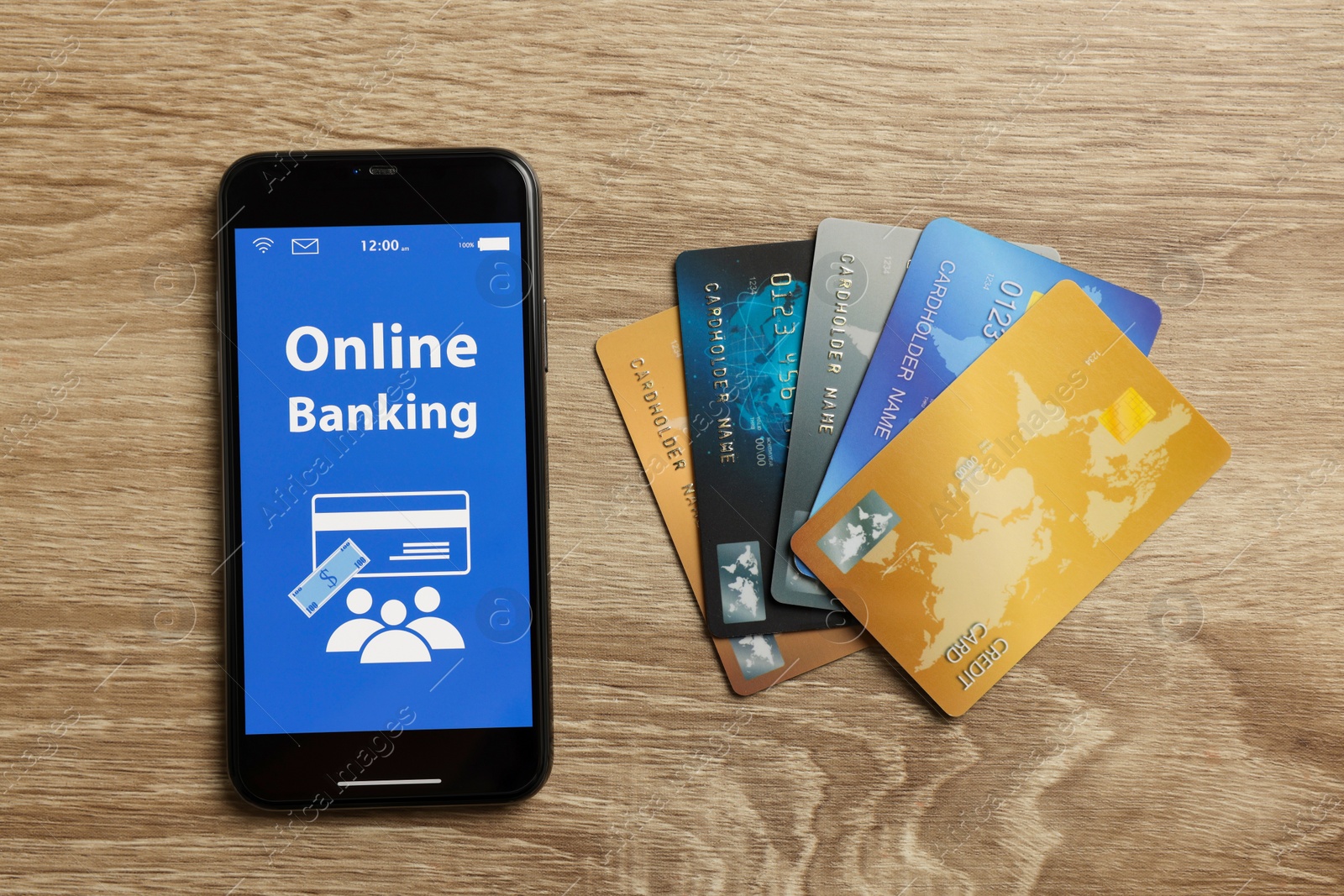 Photo of Smartphone with online banking application and credit cards on wooden table, flat lay