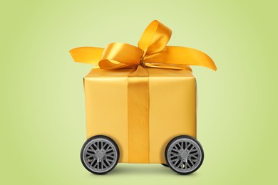 Image of Gift box on wheels against yellowish green background. Delivery service