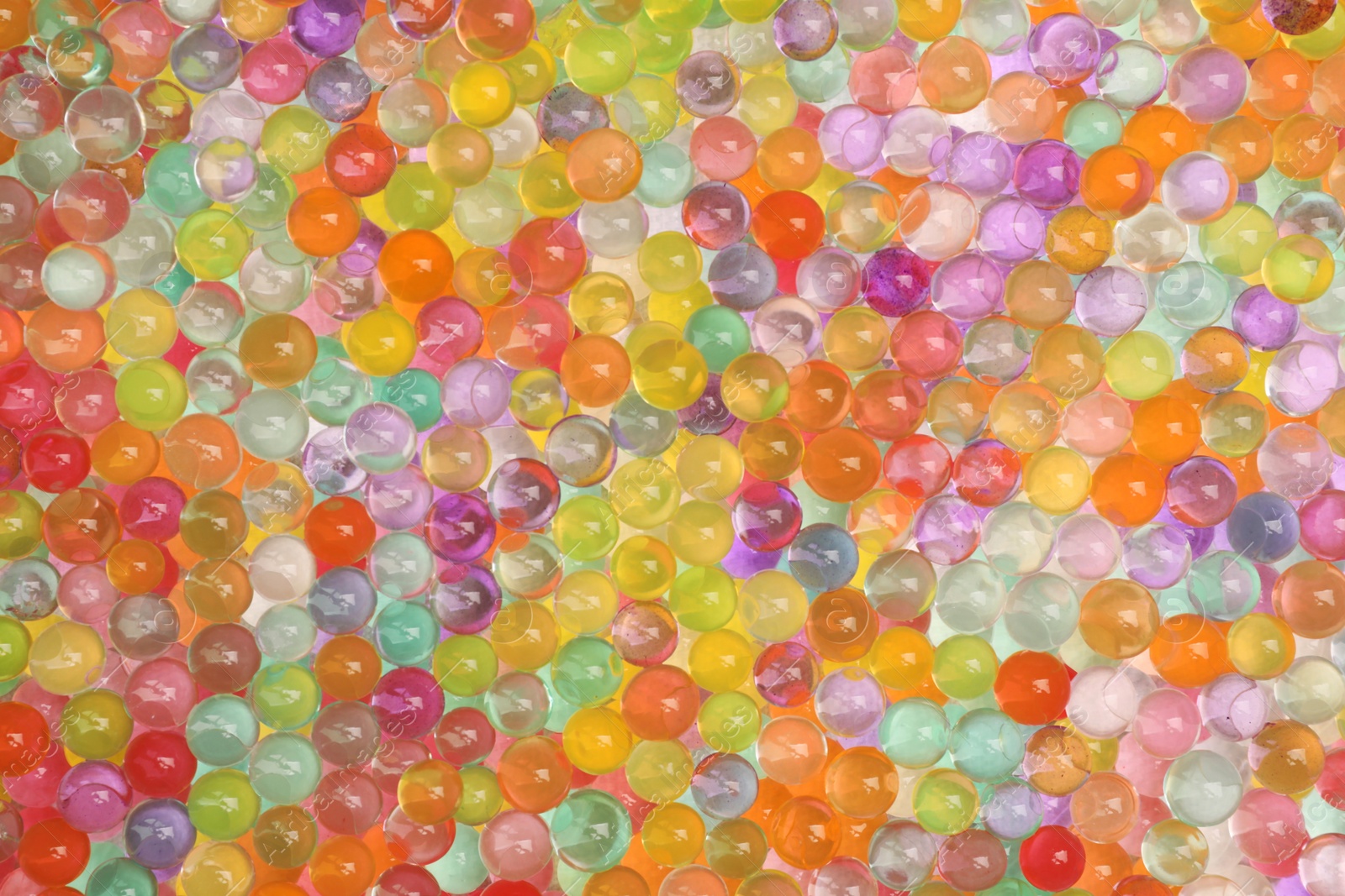 Photo of Closeup view of different color vase fillers as background. Water beads