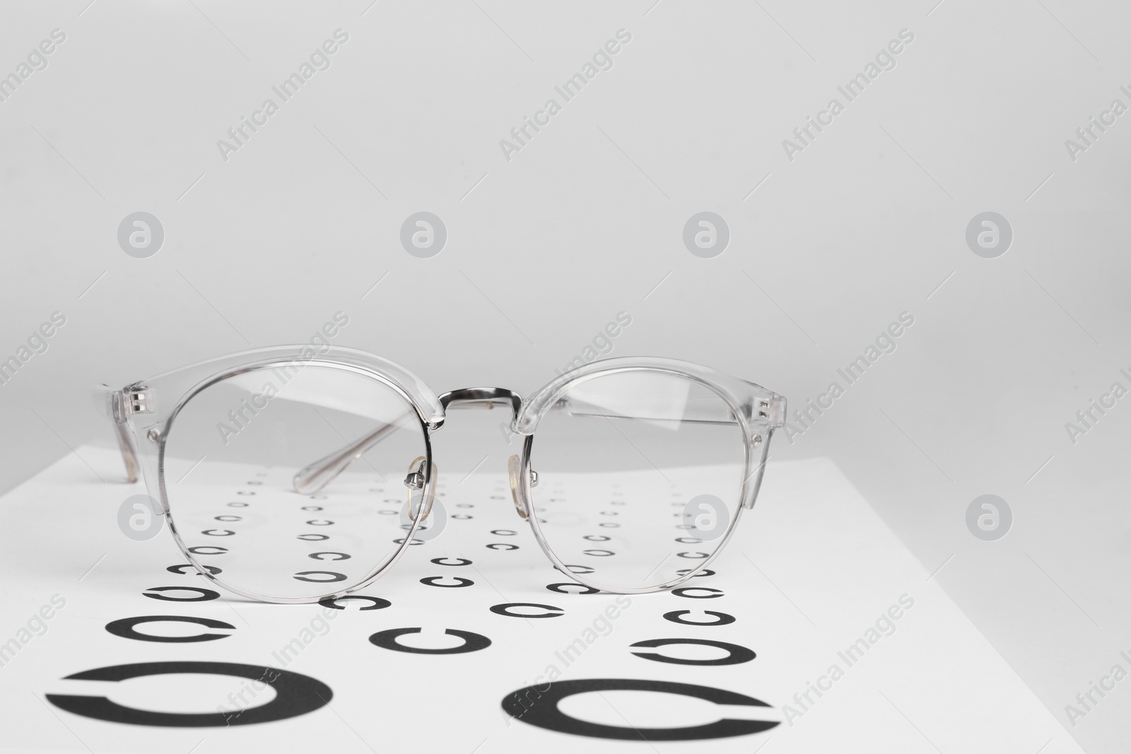 Photo of Glasses and vision test chart isolated on white