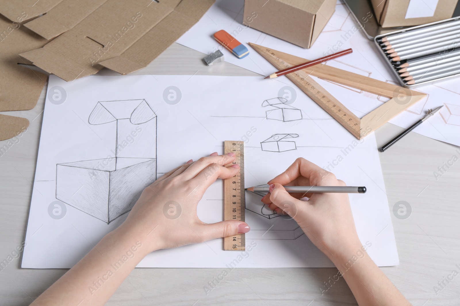 Photo of Woman creating packaging design at light wooden table, closeup