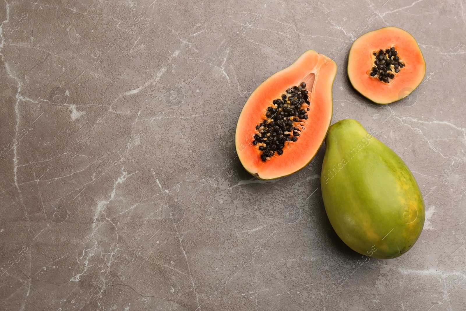 Photo of Fresh ripe papaya fruits on grey table, flat lay. Space for text