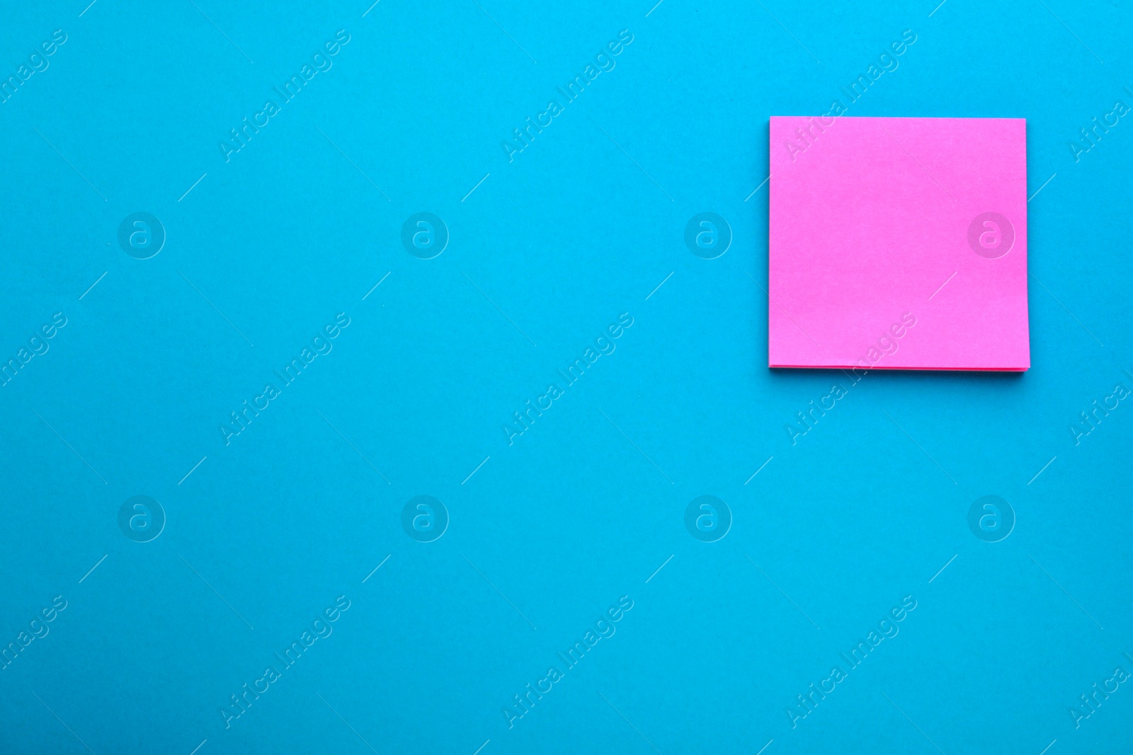 Photo of Paper note on blue background, top view. Space for text