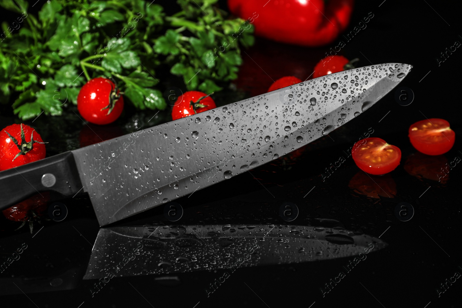 Photo of Chef's knife and products on black background