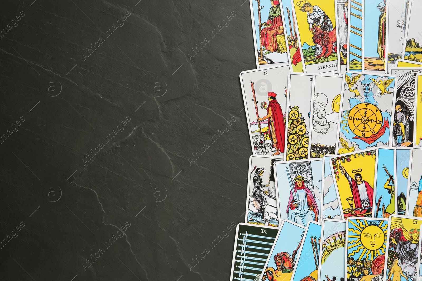 Photo of Tarot cards on black table, top view. Space for text