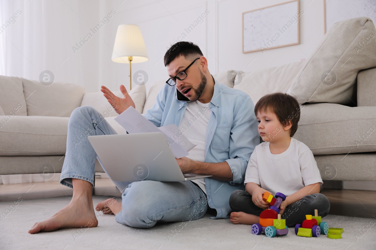 Photo of Multitasking man combining parenting and work at home