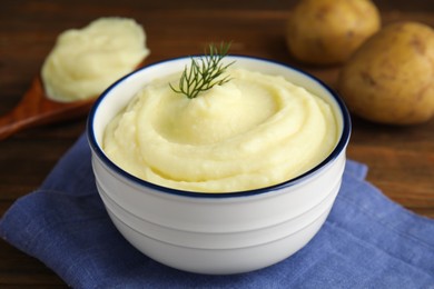 Photo of Freshly cooked homemade mashed potatoes with napkin on wooden table, closeup