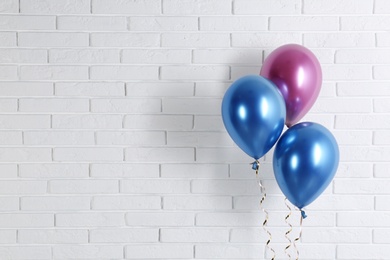 Photo of Bright colorful balloons near brick wall, space for text. Party time