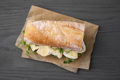 Photo of Tasty sandwich with brie cheese on grey wooden table, top view