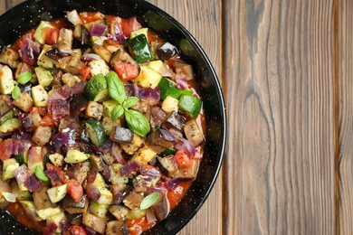 Delicious ratatouille in baking dish on wooden table, top view. Space for text