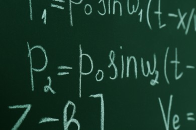 Many different math formulas written on chalkboard, closeup