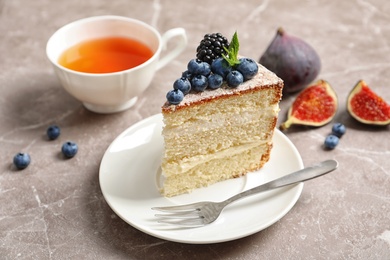 Photo of Piece of delicious homemade cake with fresh berries served on table