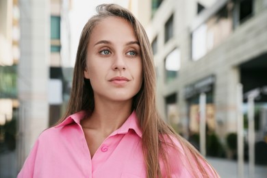 Photo of Beautiful young woman in stylish shirt on city street