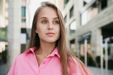 Beautiful young woman in stylish shirt on city street