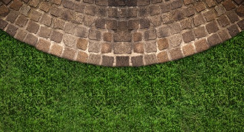Image of Fresh green grass and stone tiles outdoors, top view. Banner design