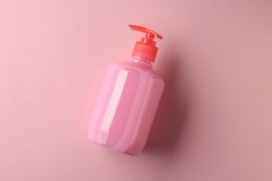 Bottle of liquid soap on pink background, top view