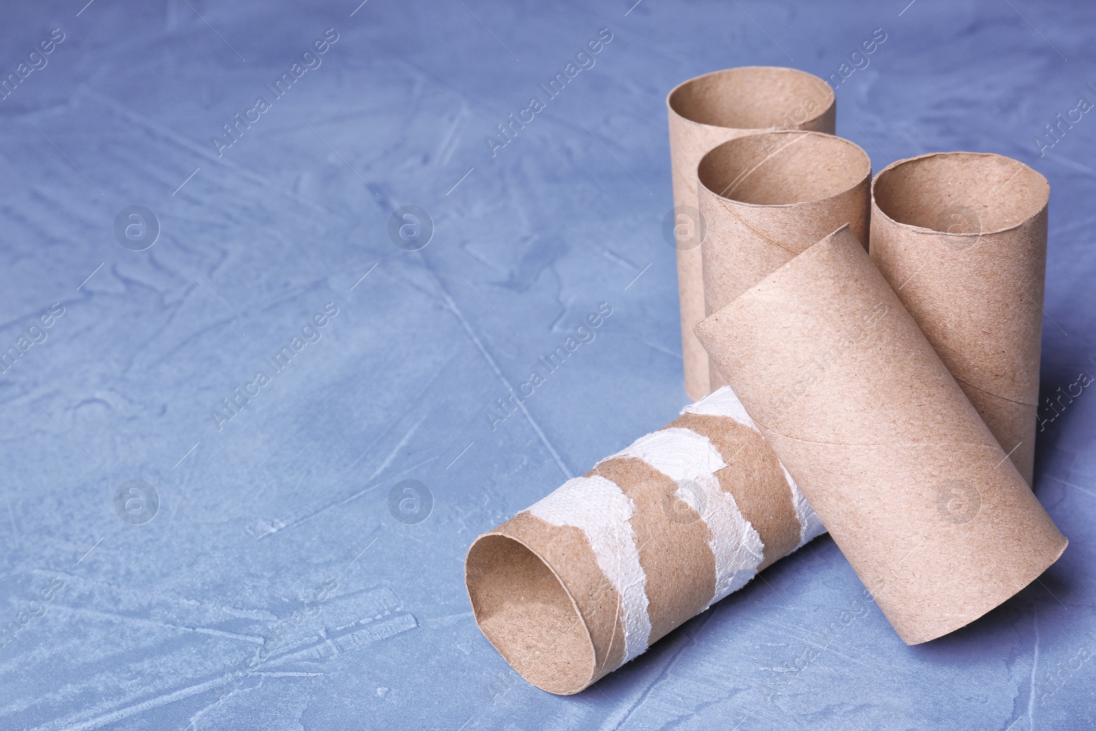 Photo of Empty toilet paper rolls and space for text on color background