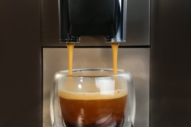 Photo of Espresso machine pouring coffee into glass, closeup