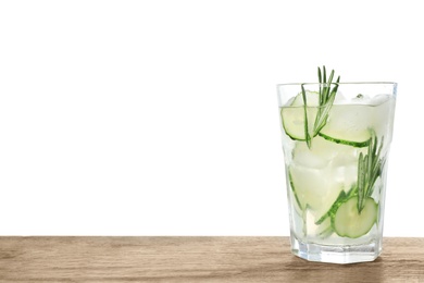 Photo of Glass of refreshing cucumber lemonade and rosemary on wooden table against white background. Summer drink