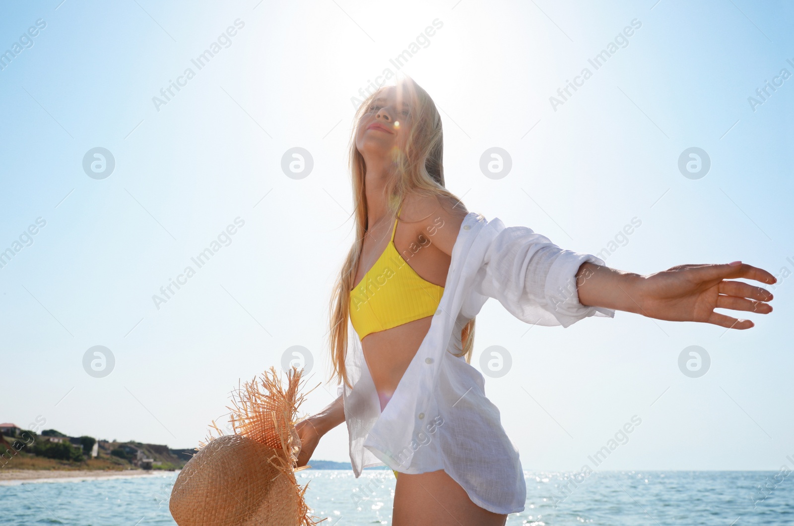 Photo of Beautiful young woman with straw hat near sea on sunny day in summer