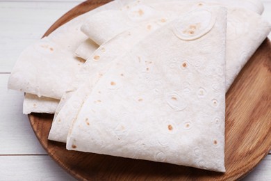 Delicious folded Armenian lavash on white wooden table, closeup