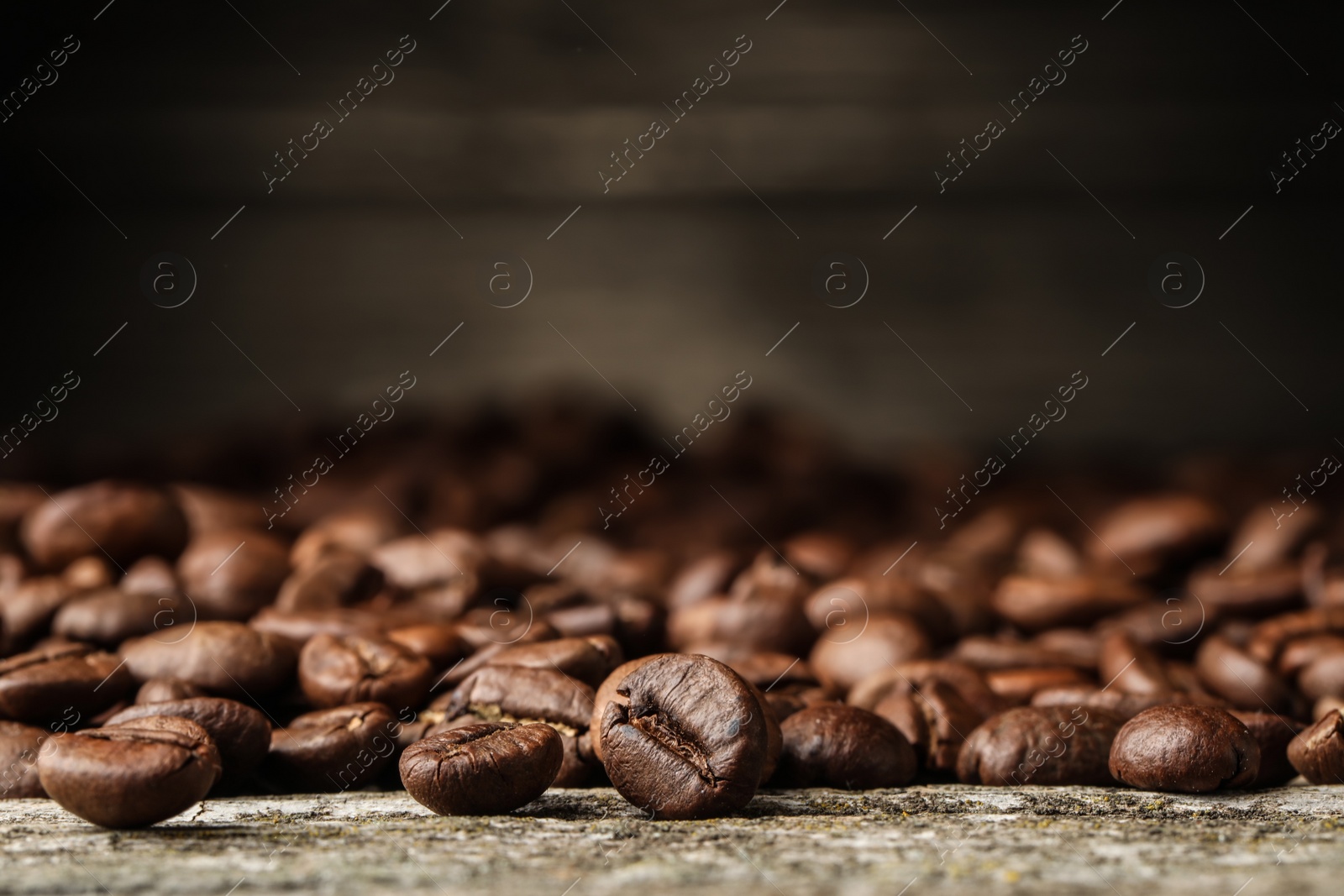 Photo of Many roasted coffee beans on wooden table, closeup