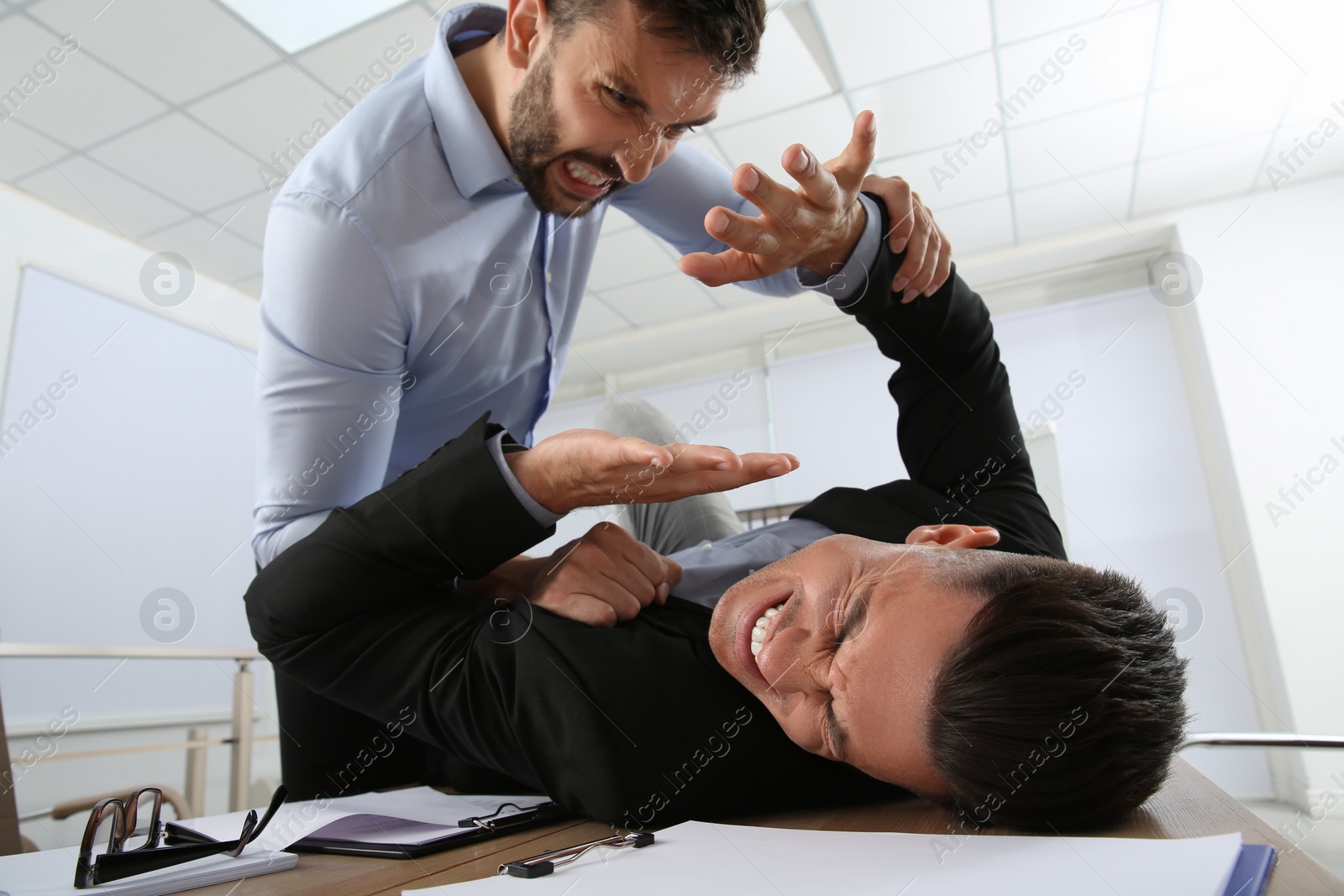 Photo of Emotional colleagues fighting in office. Workplace conflict