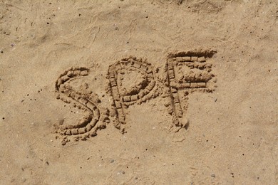 Abbreviation SPF written on sand at beach, above view