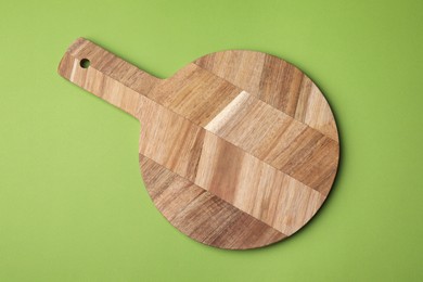 Photo of One wooden board on green background, top view