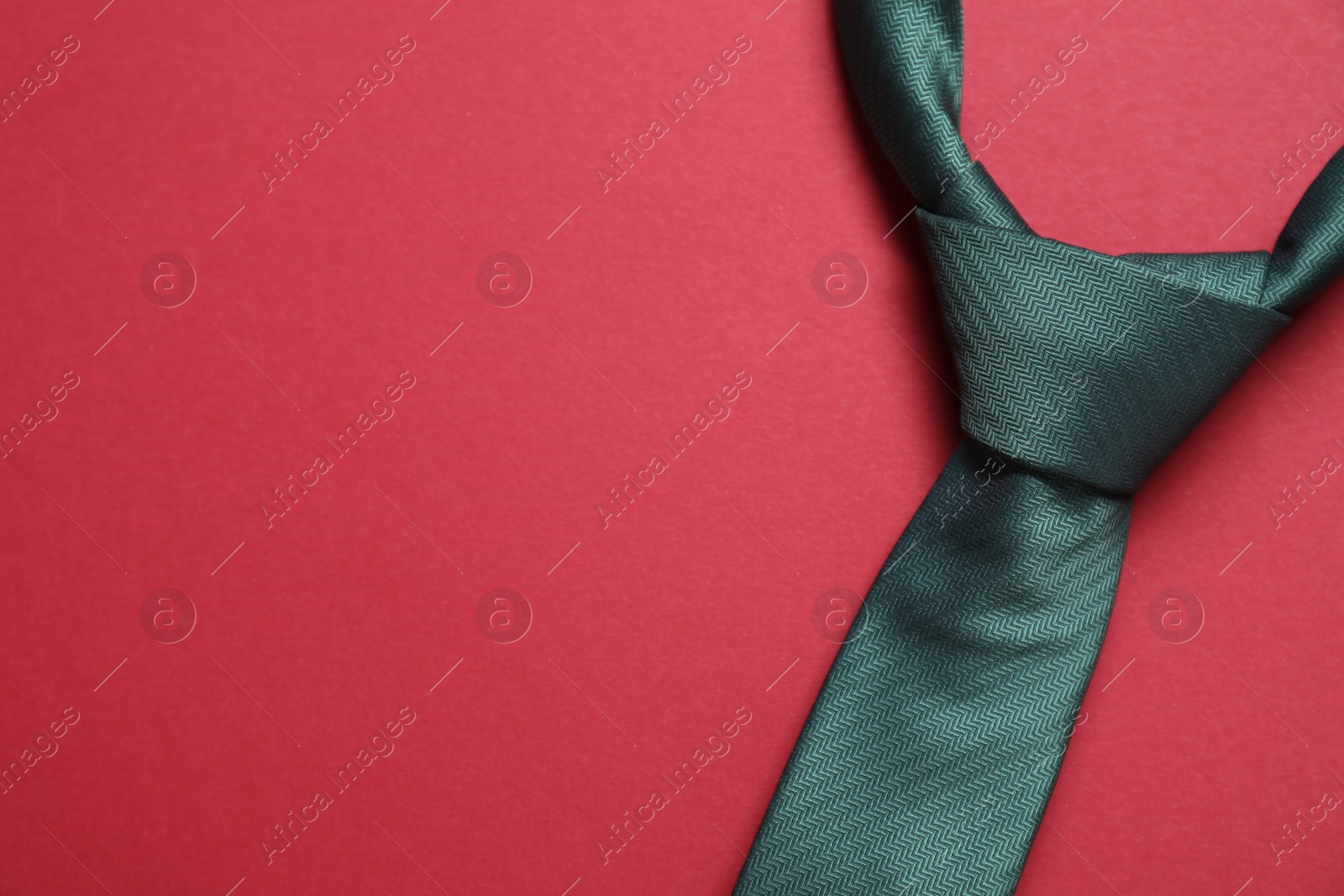 Photo of Stylish necktie on red background, top view. Space for text