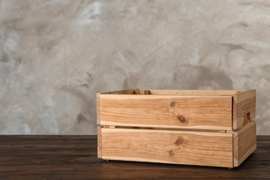 Photo of Wooden crate on table against color background. Space for text