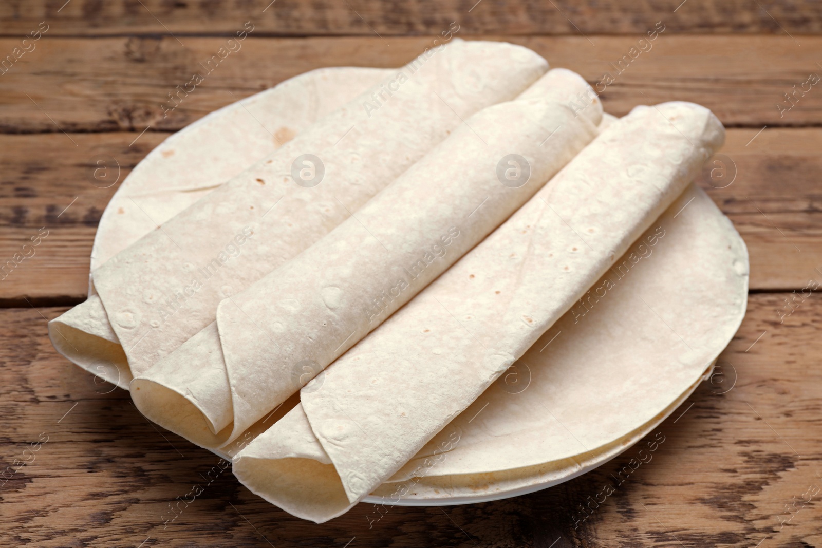 Photo of Delicious rolled Armenian lavash on wooden table