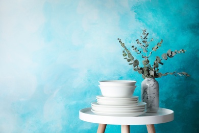 Photo of Composition with dinnerware on table against color background, space for text. Interior element