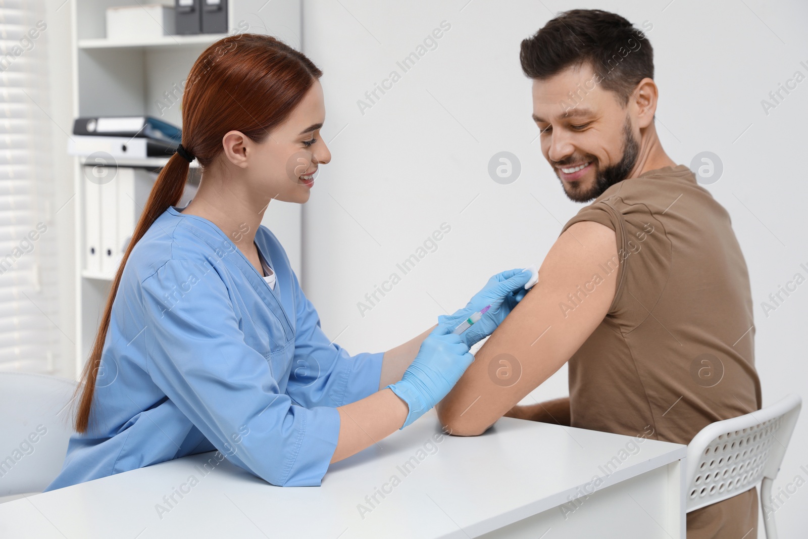 Photo of Doctor giving hepatitis vaccine to patient in clinic